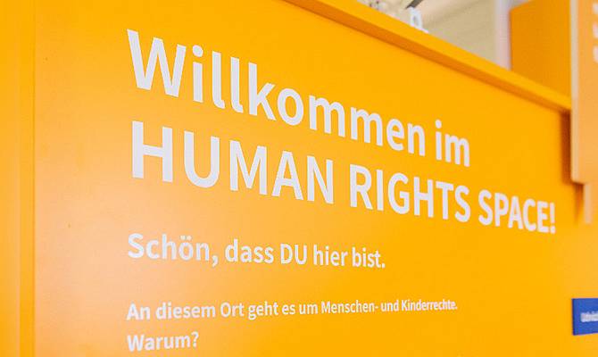 Gelbe Tafel mit weißer Schrift Willkommen im Human Rights Space